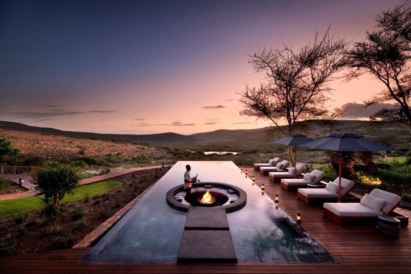 Melozhori Main Lodge: Infinity pool and sunken fire pit, dramatic mauve sunset over hills
