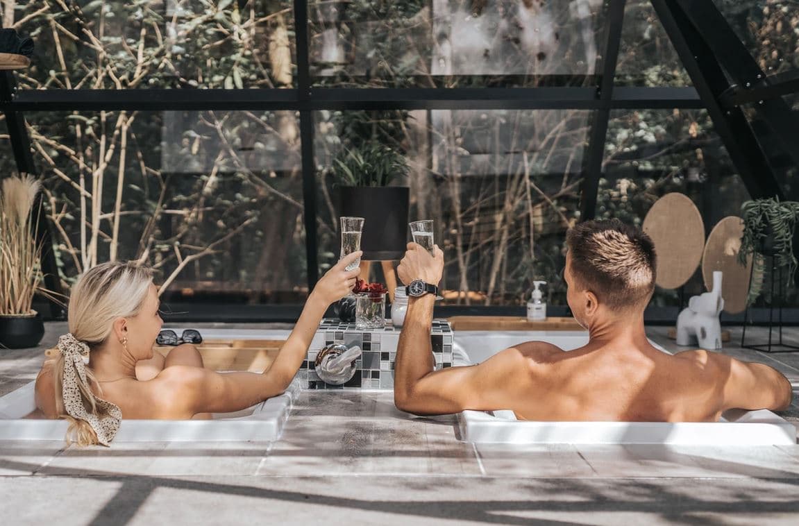 The Pyramid at Misty Mountain Reserve: Couple toasting champagne in twin tubs, steam, glass wall