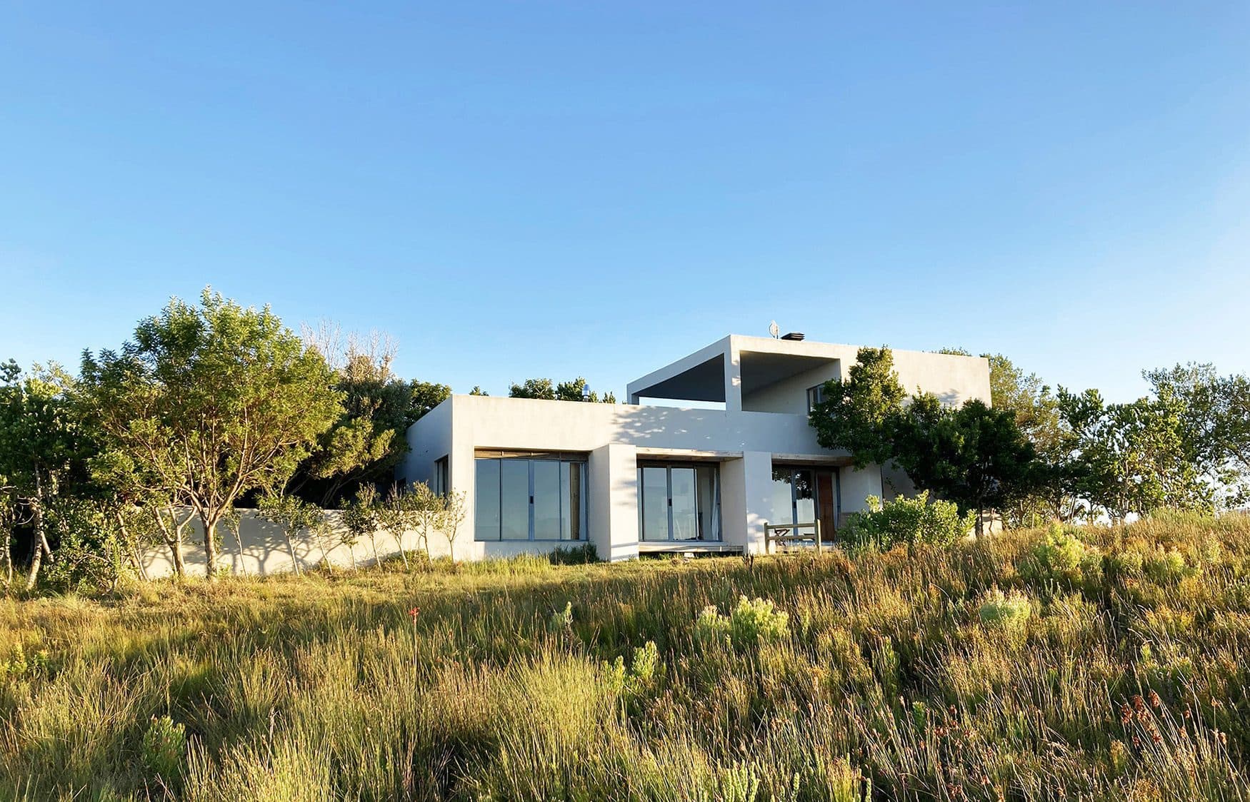 House on 215 view of the exterior of the house with white walls and big windows