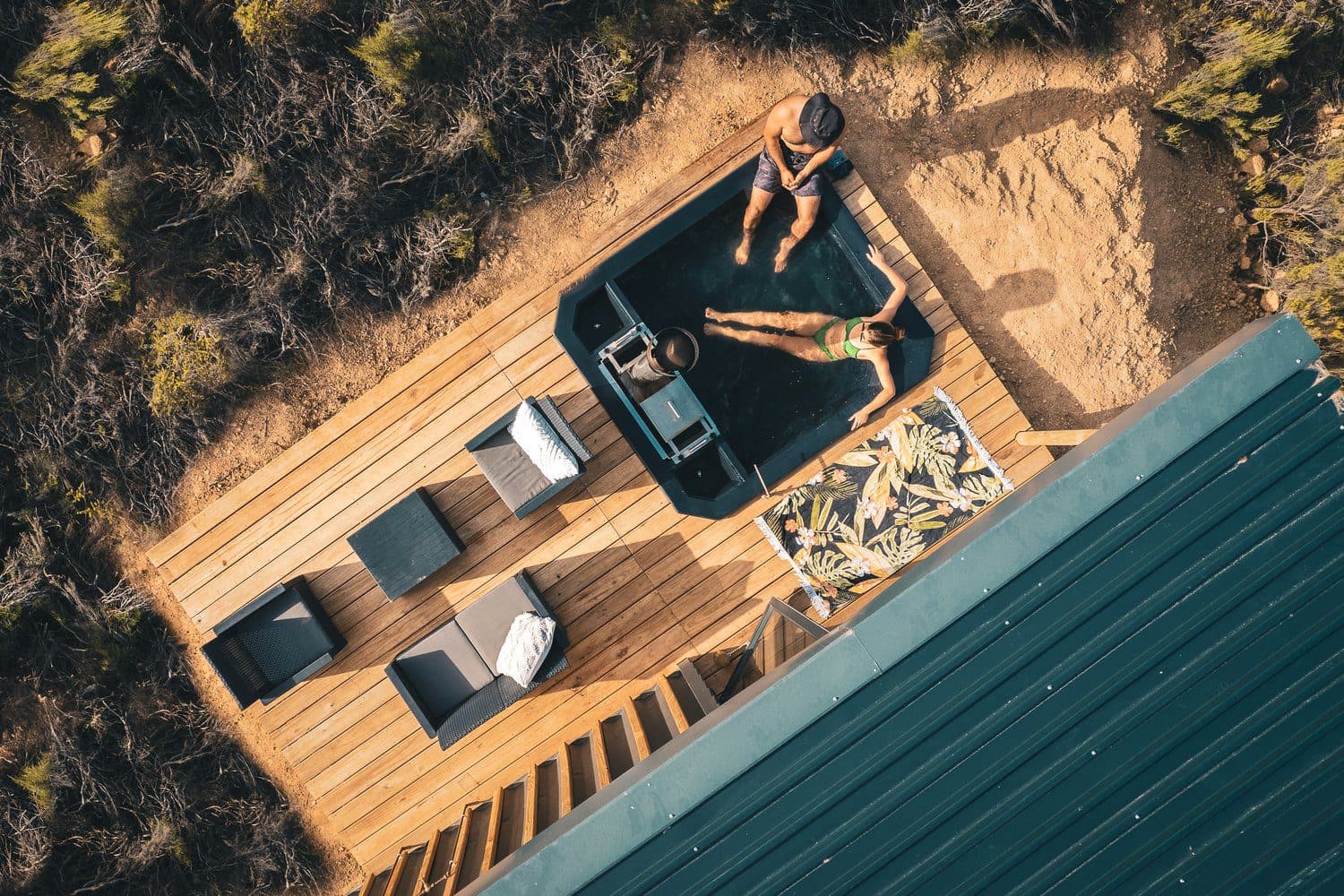 Radio Nowhere Cabin: Aerial top-down of two people in deck hot tub