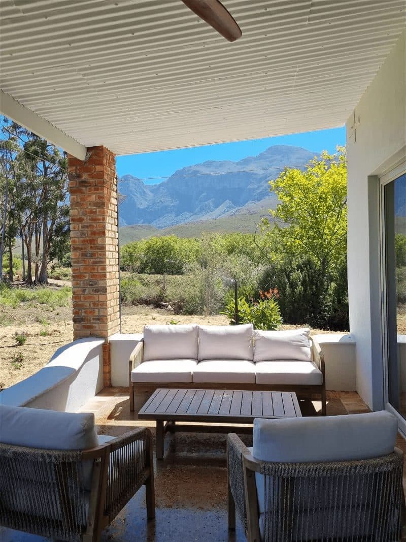 Tolbos Cottage at Bokrivier: Covered patio sofa framing dramatic Bokrivier mountain view