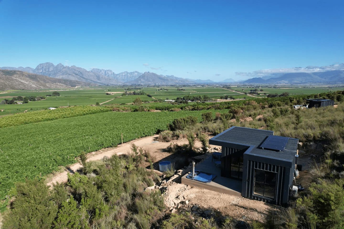 Better Days Cabin: Aerial cabin with deck above vineyards, dramatic mountain range