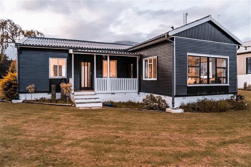 Clover Cottage at Bokrivier: Dark cabin at dusk, glowing windows, moody cloudy sky