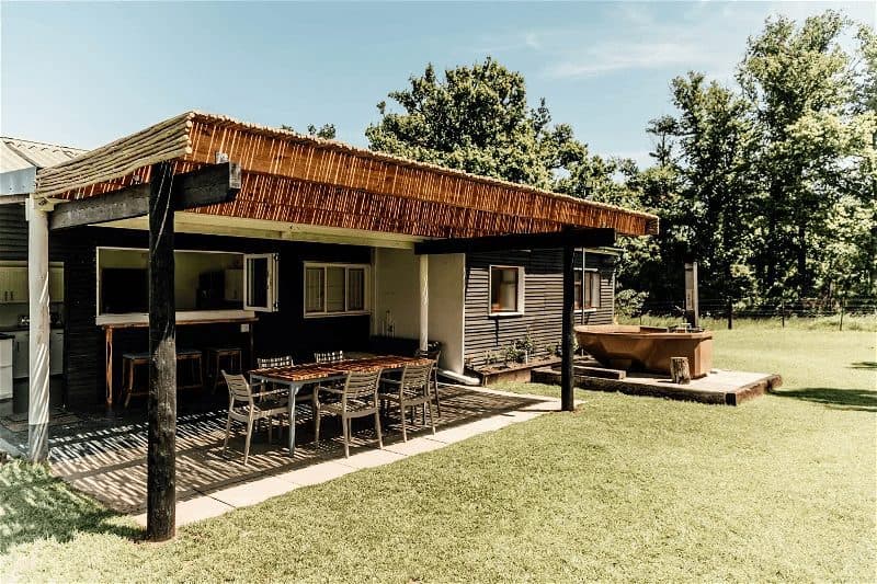 Clover Cottage at Bokrivier: Covered patio dining table, copper hot tub, trees, blue sky