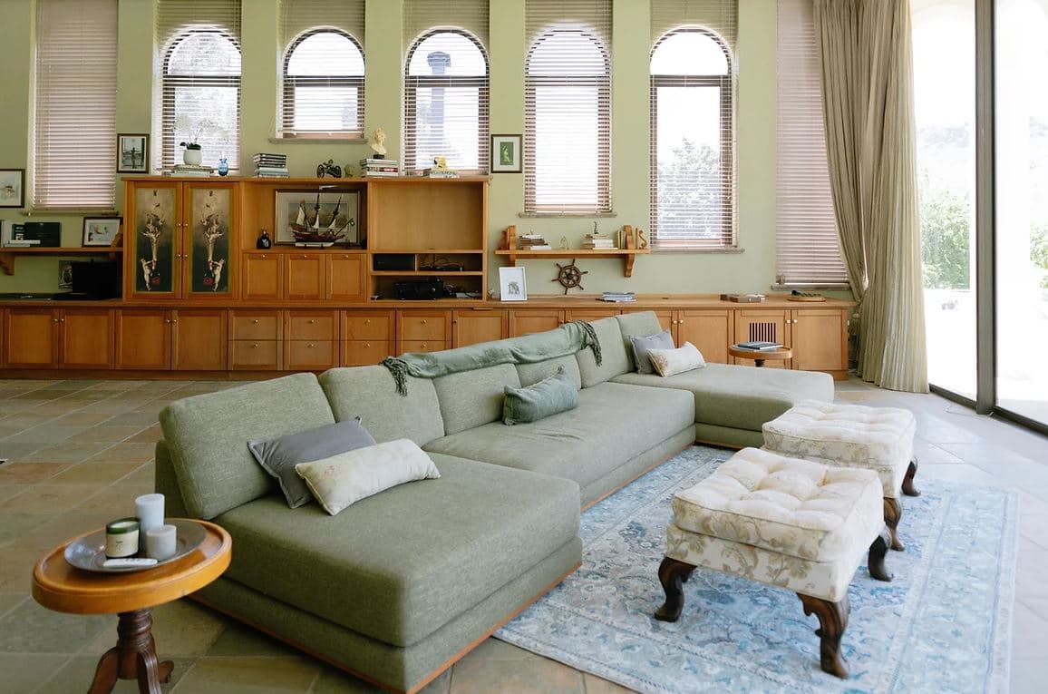 The Manor House: Light-filled lounge, arched windows, green sectional sofa