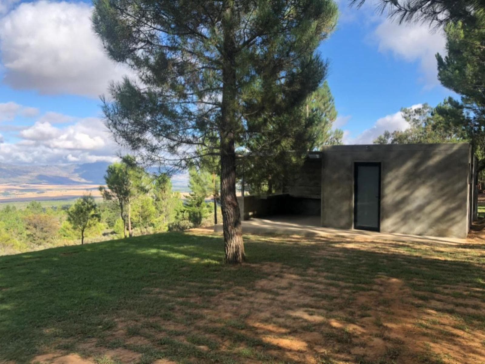 Noah Farm Campsite 2's views of the grassy lawn and ablution block on a sunny day